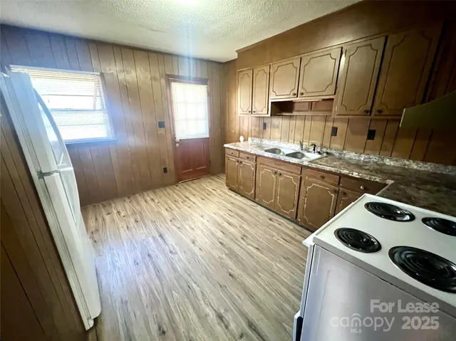 a kitchen with a sink a stove a refrigerator and cabinets