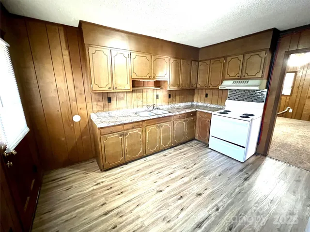a kitchen with stainless steel appliances granite countertop a sink and wooden cabinets