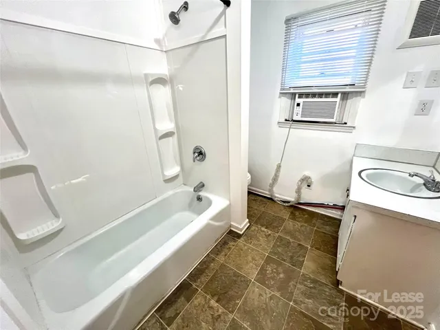 a bathroom with a tub a sink and a shower