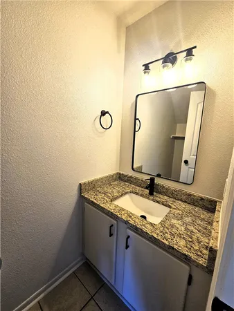 a bathroom with a granite countertop sink and a mirror