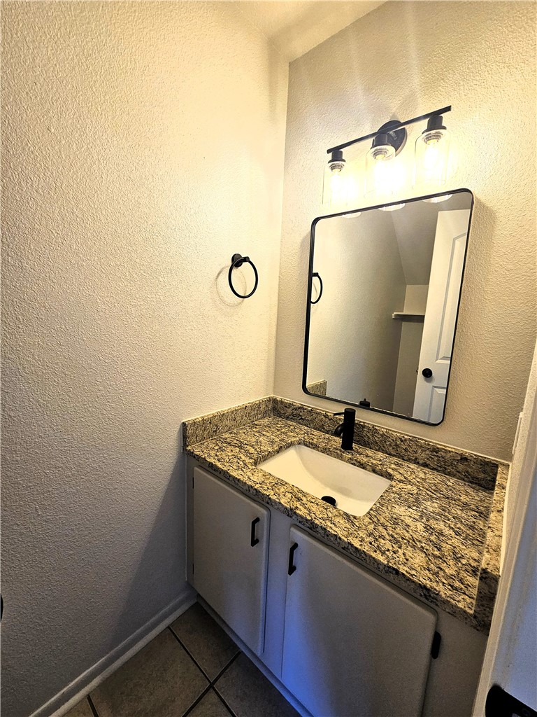 4802 Delwood Street, Unit 3 Corpus Christi, TX 78413 - Photo 11 of 22 a bathroom with a granite countertop sink and a mirror