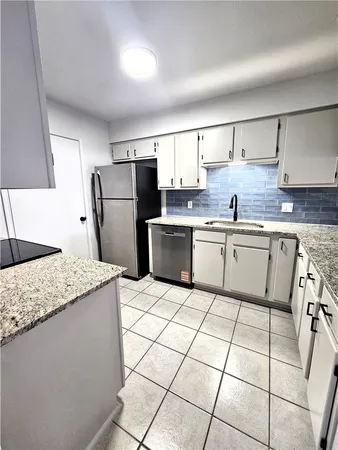 a kitchen with stainless steel appliances granite countertop a sink stove refrigerator and cabinets