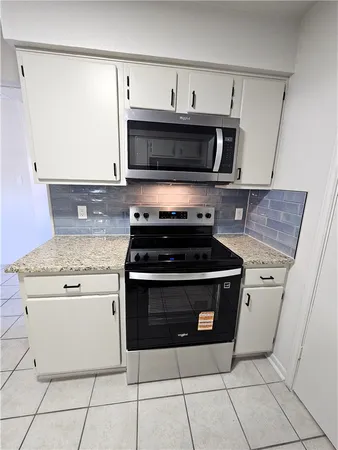 a kitchen with stainless steel appliances granite countertop a stove and a microwave