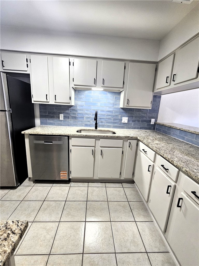 4802 Delwood Street, Unit 3 Corpus Christi, TX 78413 - Photo 7 of 22 a kitchen with stainless steel appliances granite countertop a sink stove refrigerator and cabinets