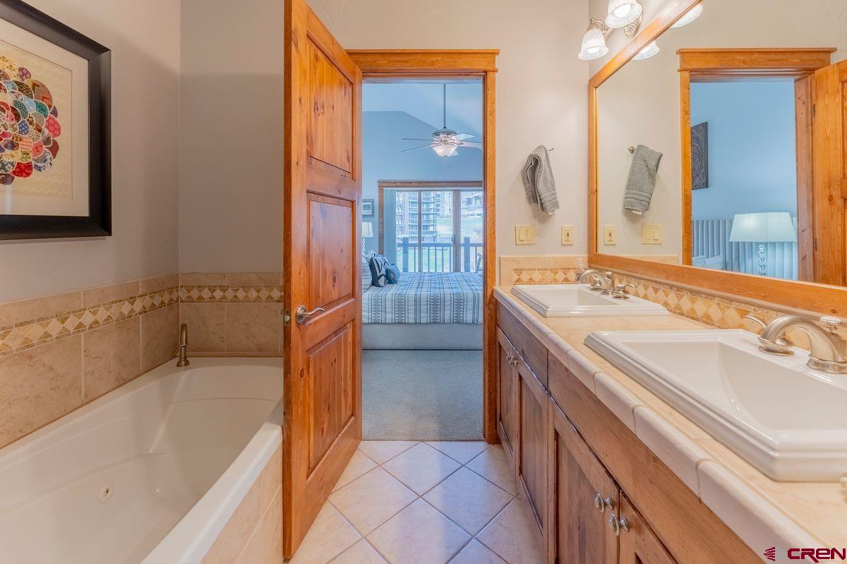 9 Hunter Hill Road, Unit 208 Crested Butte, CO 81225 - Photo 21 of 45 a spacious bathroom with a tub sink and mirror
