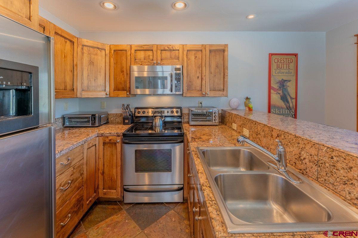 9 Hunter Hill Road, Unit 208 Crested Butte, CO 81225 - Photo 7 of 45 a kitchen with a sink and a stove top oven