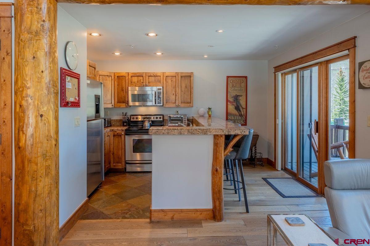 9 Hunter Hill Road, Unit 208 Crested Butte, CO 81225 - Photo 8 of 45 a kitchen with stainless steel appliances granite countertop a stove top oven a sink and a refrigerator