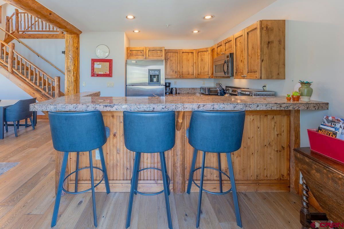 9 Hunter Hill Road, Unit 208 Crested Butte, CO 81225 - Photo 10 of 45 a kitchen with cabinets table and chairs