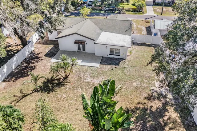 an aerial view of a house with a yard and mountain view in back