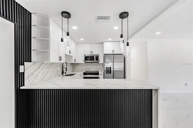 a kitchen with stainless steel appliances a refrigerator sink and stove