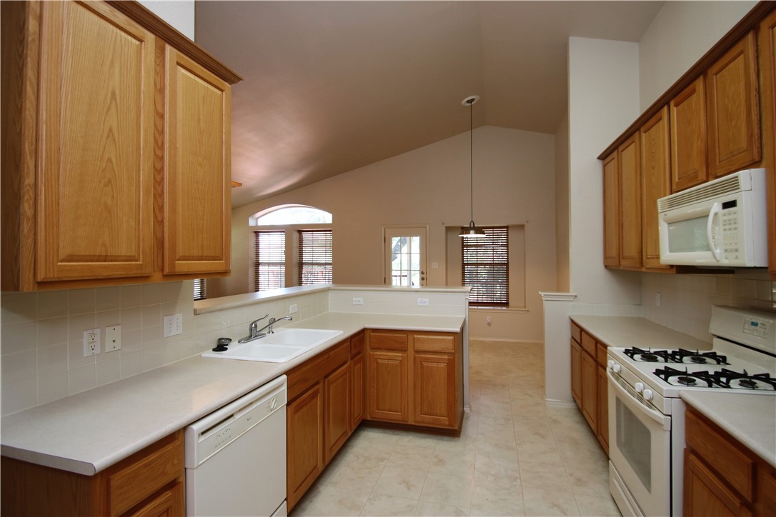 16516 Fowler Mill Cove Austin, TX 78717 - Photo 4 of 27 a kitchen with a sink stove and cabinets