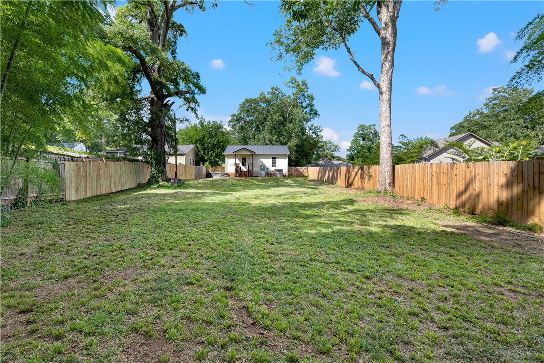 1020 Elizabeth Street Anderson, SC 29624 - Photo 20 of 22 A spacious, verdant yard with mature trees and a newly installed privacy fence frames a charming back exterior.