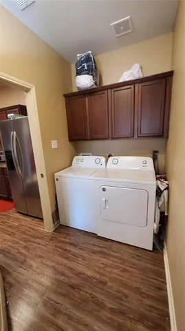 a utility room with wooden floor washer and dryer