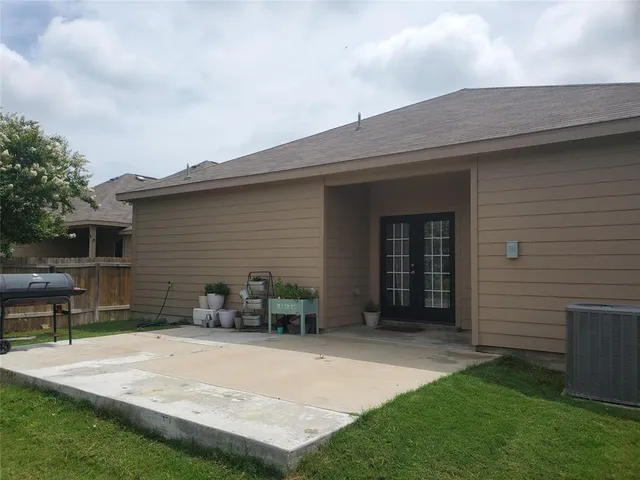 a backyard of a house with table and chairs