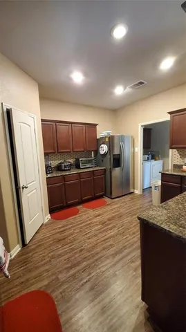 a large kitchen with stainless steel appliances and a refrigerator