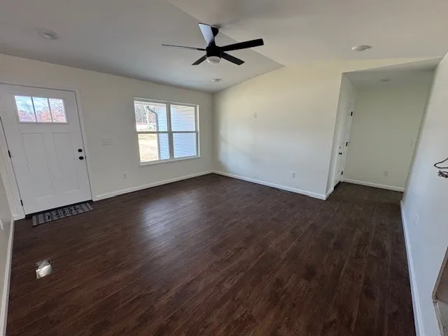 a view of a livingroom with wooden floor and a ceiling fan
