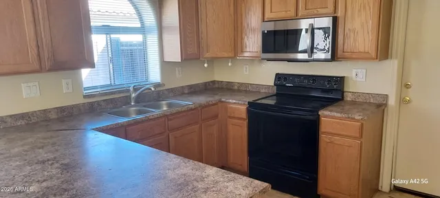 a kitchen with stainless steel appliances granite countertop a sink stove and microwave