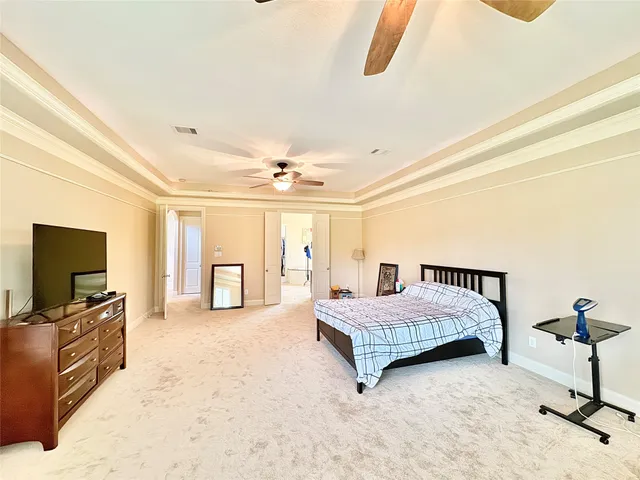 a spacious bedroom with a bed and a flat screen tv