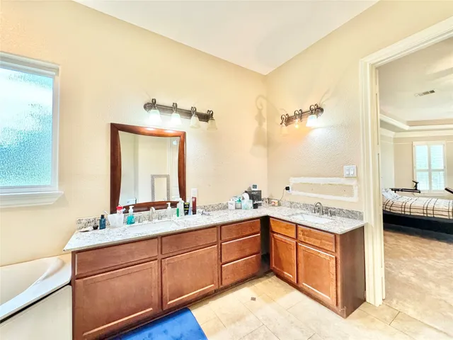 a spacious bathroom with a granite countertop sink a mirror and a
