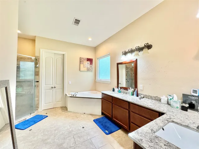 a bathroom with a tub sink and mirror