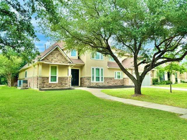 a front view of a house with a yard and trees