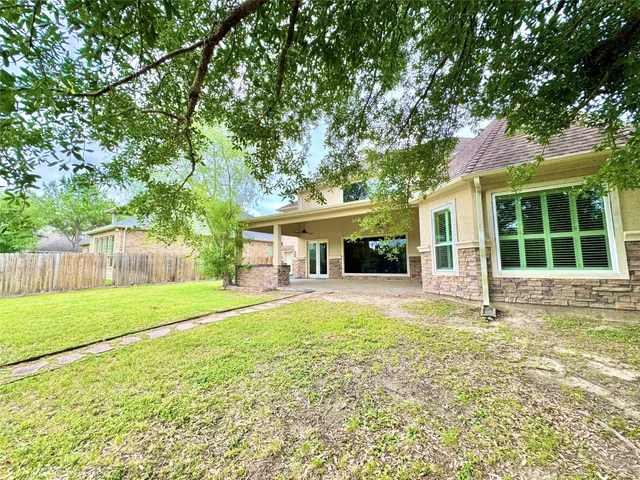 a view of a house with a yard and large tree