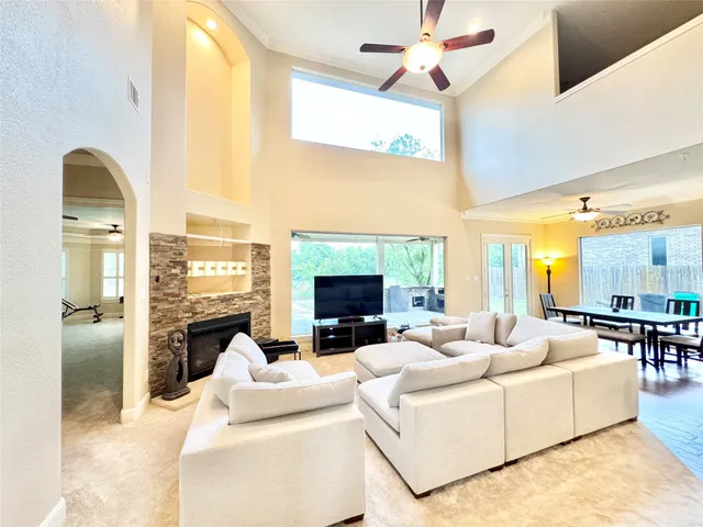 a living room with fireplace furniture and a large window