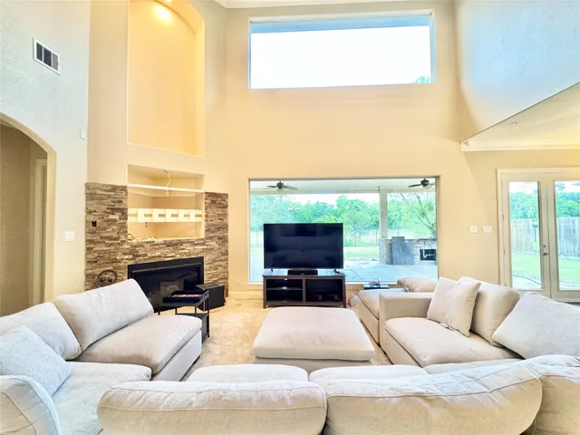 a living room with furniture large windows and a flat screen tv