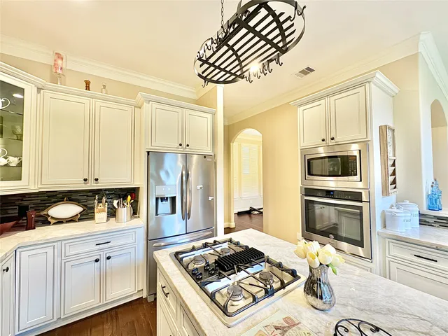 a kitchen with stainless steel appliances granite countertop a stove refrigerator and cabinets