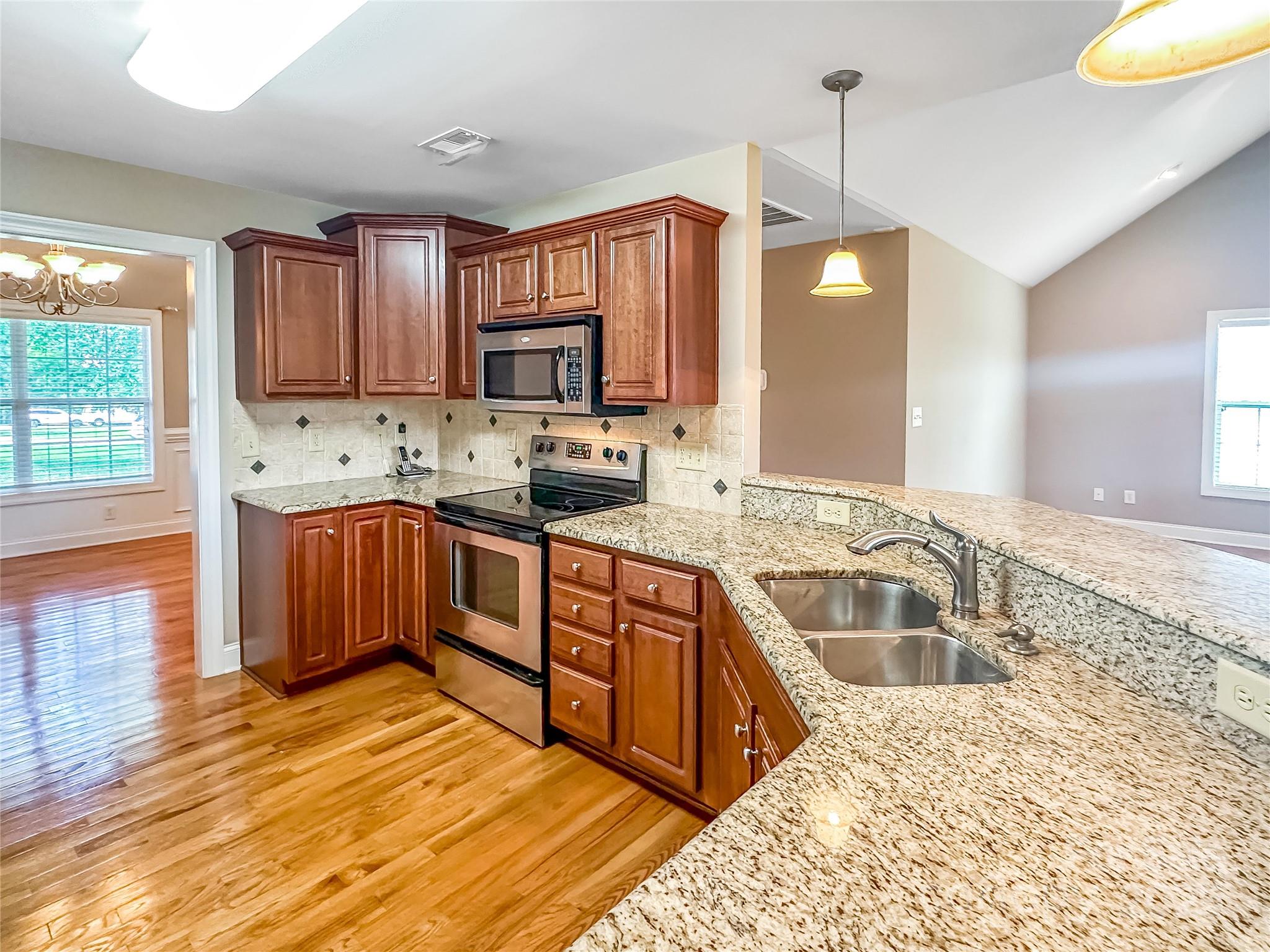 1625 Damascus Circle Conover, NC 28613 - Photo 7 of 40 a large kitchen with stainless steel appliances wooden cabinets a sink and a stove