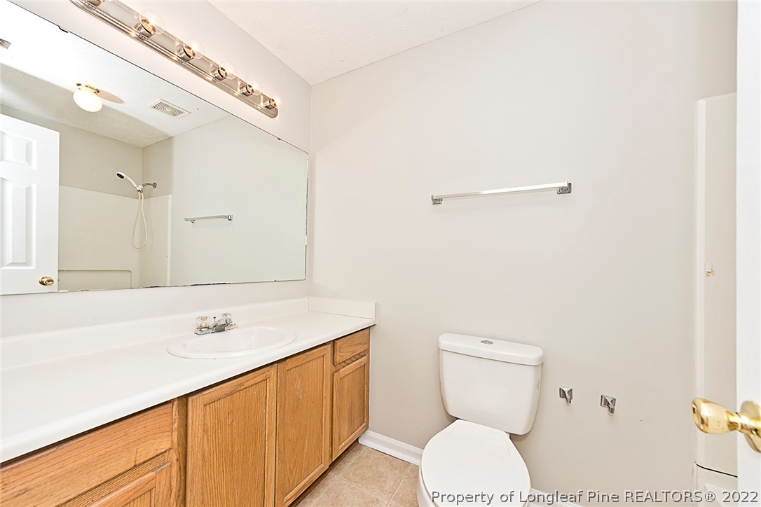 406 Kernstown Road Raeford, NC 28376 - Photo 16 of 22 a bathroom with a sink a toilet and a mirror
