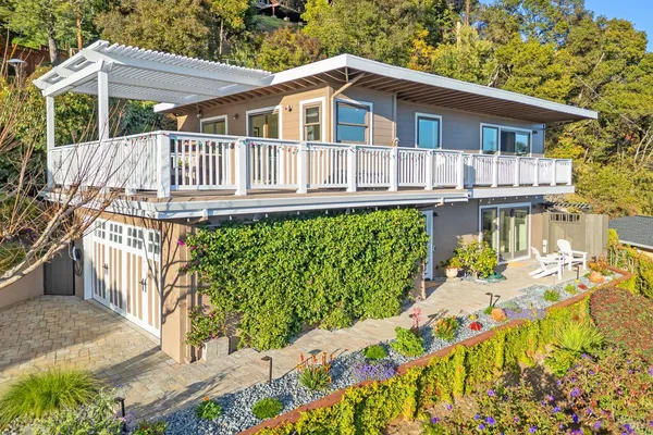 a view of a house with wooden deck front of house