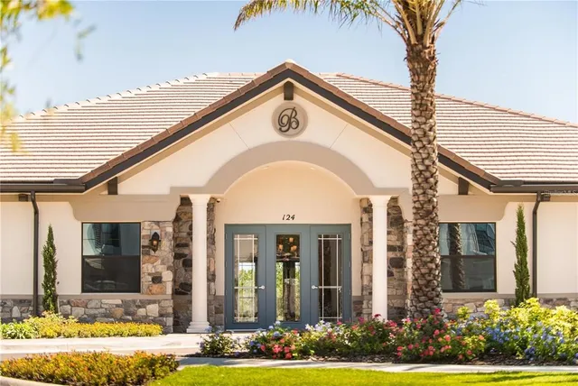 a view of a white house with a large windows and a yard
