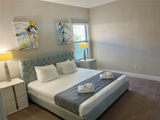 a bed sitting in a bedroom next to a window