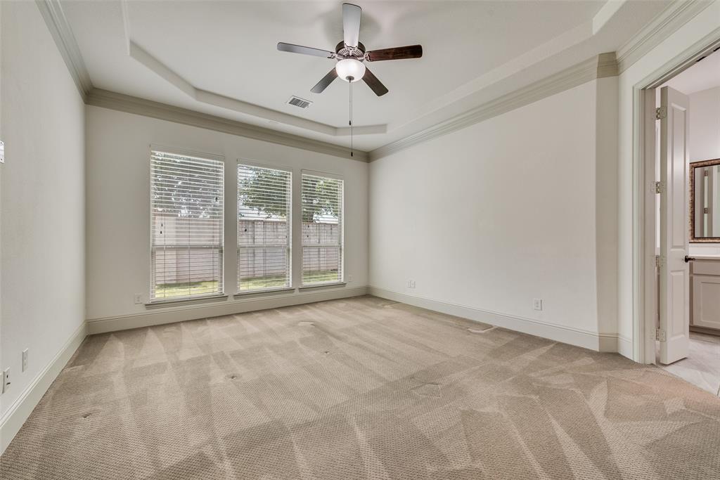 2021 Calisto Way Allen, TX 75013 - Photo 19 of 34 Spacious room featuring a tray ceiling with a ceiling fan, three large windows with blinds, plush carpeting, and crown molding