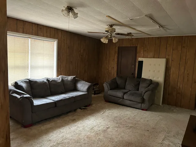 a living room with furniture and a ceiling fan