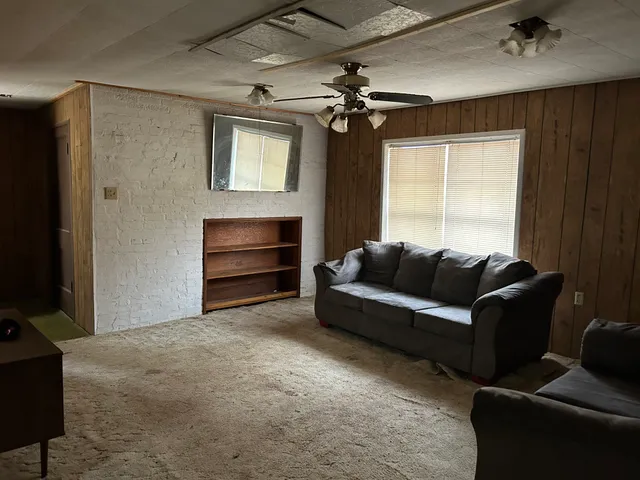 a living room with furniture a ceiling fan and a window