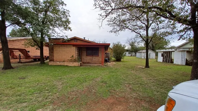 a view of a house with backyard and tree