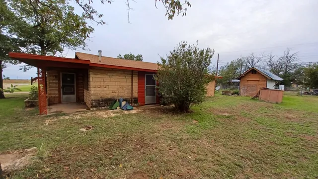 a view of a house with backyard and trees