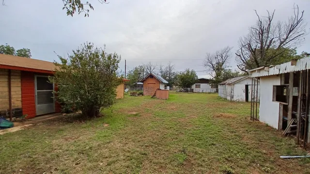 a backyard of a house with barbeque oven fire pit table and chairs