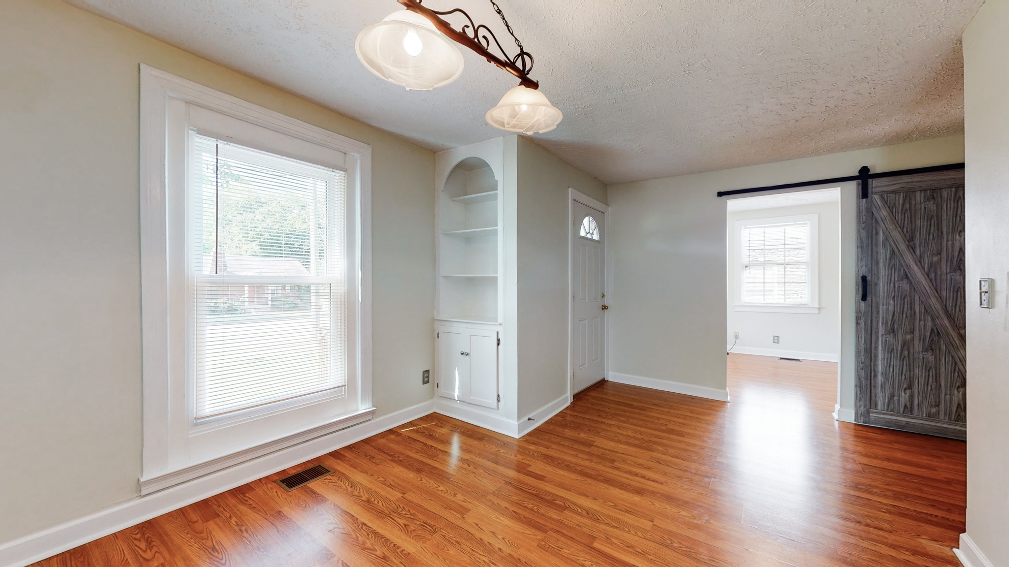 343 Neelys Bend Road Madison, TN 37115 - Photo 6 of 28 a view of an empty room with wooden floor and a window