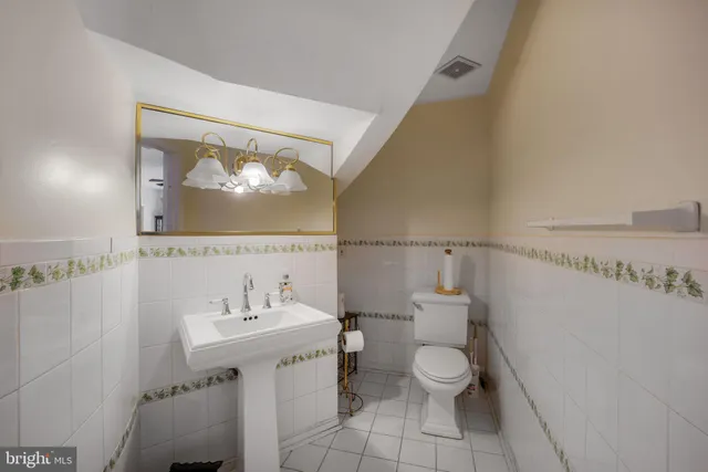 a bedroom with a bed and dresser with wooden floor