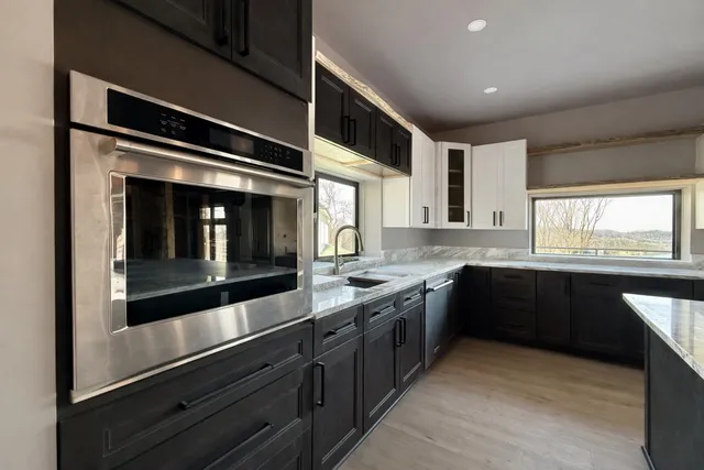 a large kitchen with stainless steel appliances and large cabinets