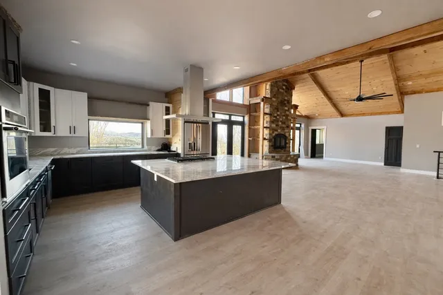 a large kitchen with stainless steel appliances granite countertop a large counter top and sink