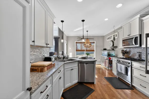 a kitchen with stainless steel appliances granite countertop a sink stove and refrigerator