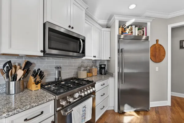 a kitchen with granite countertop a stove and a refrigerator