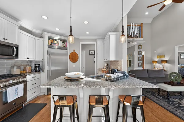 a kitchen with granite countertop white cabinets and stainless steel appliances