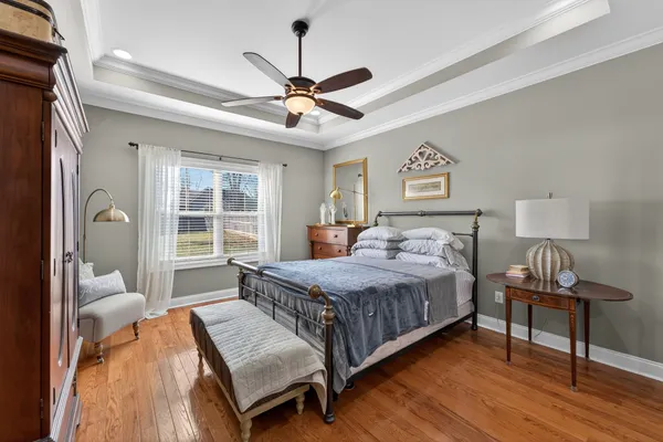 a bedroom with a bed wooden floor and a table