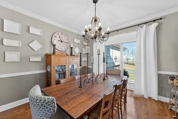 a dining room with furniture a chandelier and wooden floor
