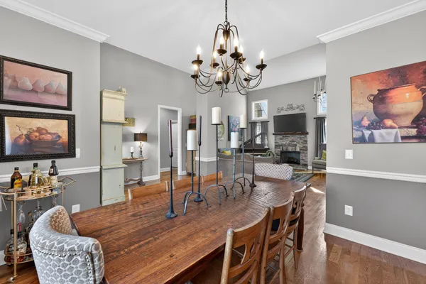 a dining room with furniture a livingroom kitchen view and wooden floor